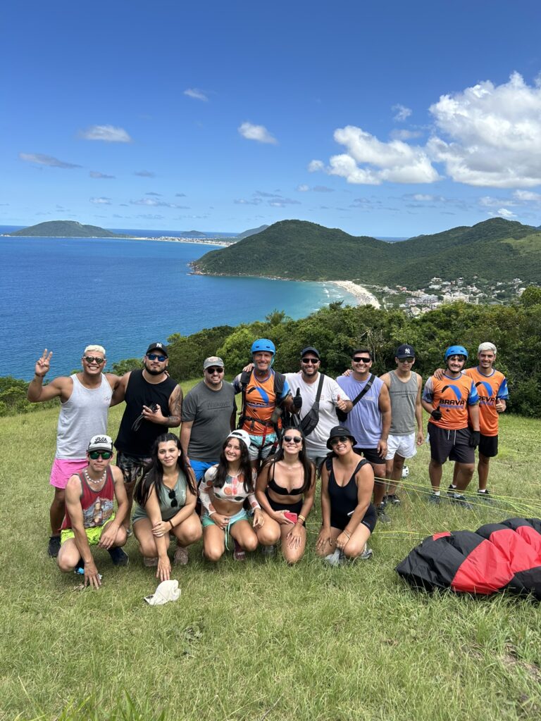 Equipe da Brava Parapente e clientes felizes após realização do passeio. Equipe Brava Parapente na Praia Brava - Morro do Rapa